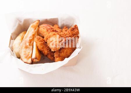 Une bande de poulet et des frites dans un récipient à emporter Banque D'Images