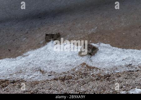 Phénomène inhabituel des vagues de glace capturé au lac Joux en Suisse. L'eau du lac est gelée et des cristaux de glace sont accumulés sur la plage Banque D'Images