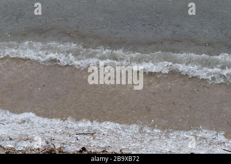 Phénomène inhabituel des vagues de glace capturé au lac Joux en Suisse. L'eau du lac est gelée et des cristaux de glace sont accumulés sur la plage Banque D'Images