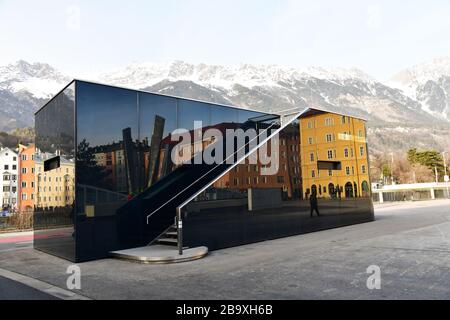 Station de pompage d'eau sur le marché d'Innsbruck dans un design contemporain en verre.réflexions visibles des bâtiments historiques environnants Banque D'Images