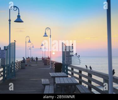 Jetée avec lampes pendant le coucher du soleil à Daytona Beach, Floride Banque D'Images