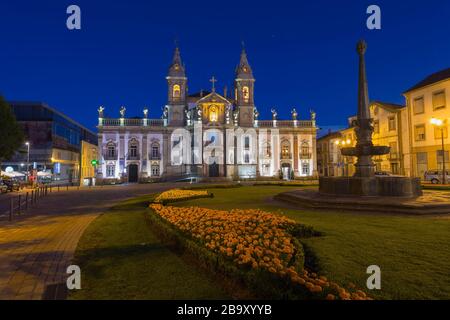 La place Carlos Amarante au coucher du soleil avec l'église illuminée Sao Marcos du XVIIIe siècle et l'ancien hôpital transformé en un hôtel, Braga, Minho, Portugal Banque D'Images