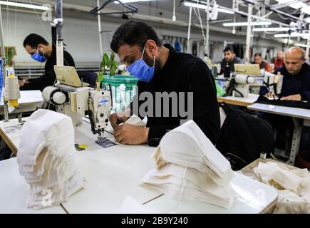 Gaza. 25 mars 2020. Le 25 mars 2020, les travailleurs palestiniens ont couté des masques dans une usine située à l'est de la ville de Gaza. La Palestine a déclaré mercredi que deux nouveaux cas de COVID-19 étaient positifs, portant à 62 le nombre total d'infectés dans ses territoires. La production de vêtements et de masques médicaux dans les usines a récemment augmenté. Crédit: Yasser Qudih/Xinhua/Alay Live News Banque D'Images