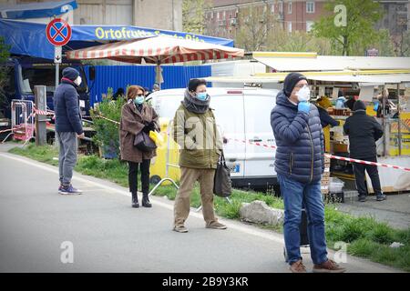 File d'attente des personnes debout pour faire des achats, file d'attente pour le marché extérieur. Distanciation sociale. Mesures préventives. Turin, Italie - Mars 2020 Banque D'Images