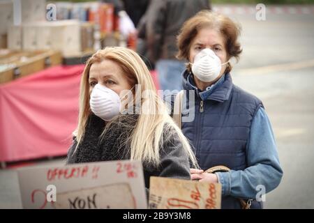 Les gens, avec des masques pour la protection de COVID-19, font du shopping de légumes et de fruits sur le marché. Turin, Italie - Mars 2020 Banque D'Images