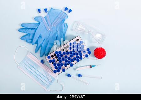 Plusieurs objets de laboratoire, dont un masque de protection, un portoir pour flacons, des tubes de test et d'autres produits. Banque D'Images