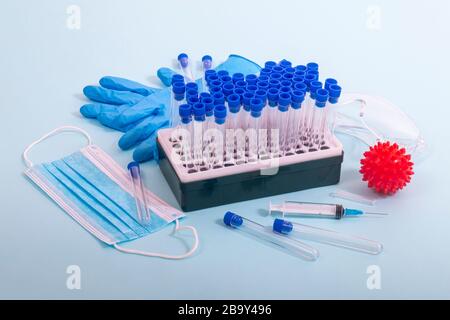 Plusieurs objets de laboratoire, dont un masque de protection, un portoir pour flacons, des tubes de test et d'autres produits. Banque D'Images