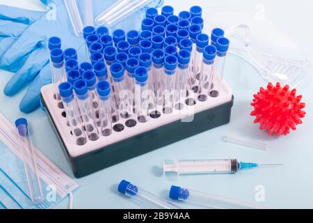 Plusieurs objets de laboratoire, dont un masque de protection, un portoir pour flacons, des tubes de test et d'autres produits. Banque D'Images