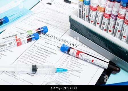 Plusieurs échantillons de sang fictif infectés avec divers virus avec un rapport de laboratoire, un masque et une seringue. Banque D'Images