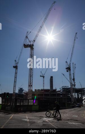 Manchester, Royaume-Uni. 25 mars 2020. Un travailleur de la construction quitte un site pour sa pause déjeuner. Le Cabinet Office a confirmé que la construction en Angleterre peut se poursuivre tant qu'elle peut être effectuée en toute sécurité et en suivant les directives de Santé publique Angleterre. La sécurité des travailleurs de la construction a été largement controversée en raison de la propagation du coronavirus. Crédit : Andy Barton/Alay Live News Banque D'Images