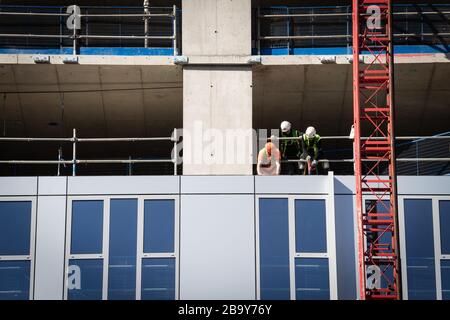 Manchester, Royaume-Uni. 25 mars 2020. Les travailleurs de la construction installent des travaux de revêtement à proximité les uns des autres. Le Cabinet Office a confirmé que la construction en Angleterre peut se poursuivre tant qu'elle peut être effectuée en toute sécurité et en suivant les directives de Santé publique Angleterre. La sécurité des travailleurs de la construction a été largement controversée en raison de la propagation du coronavirus. Crédit : Andy Barton/Alay Live News Banque D'Images