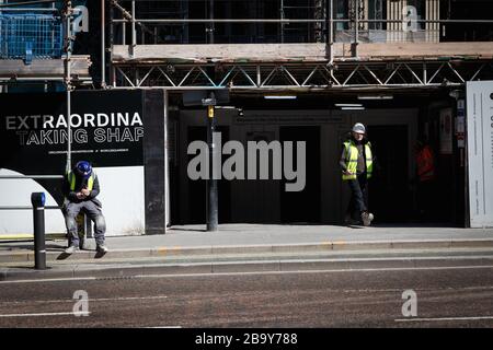 Manchester, Royaume-Uni. 25 mars 2020. Un travailleur de la construction quitte le site pour sa pause-déjeuner.le Cabinet Office a confirmé que la construction en Angleterre peut se poursuivre tant qu'elle peut être faite en toute sécurité et suivant les directives de Santé publique Angleterre. La sécurité des travailleurs de la construction a été largement controversée en raison de la propagation du coronavirus. Crédit : Andy Barton/Alay Live News Banque D'Images