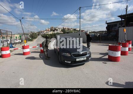 Tulkarem. 25 mars 2020. Les policiers palestiniens travaillent à un point de contrôle à l'entrée de la ville de Tulkarem, en Cisjordanie, le 25 mars 2020. La Palestine a déclaré mercredi que deux nouveaux cas de COVID-19 étaient positifs, portant à 62 le nombre total d'infectés dans ses territoires. Crédit: Nidal Eshtayeh/Xinhua/Alay Live News Banque D'Images