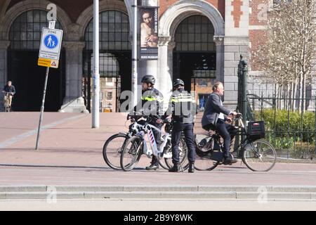 Amsterdam, Pays-Bas. 25 mars 2020. Deux policiers néerlandais patrouilles pour la pratique de la distanciation sociale et se tenir à 1,5 mètre au Museumplein le 25 mars 2020 à Amsterdam, aux Pays-Bas. Le ministre néerlandais de la Justice et de la sécurité Ferdinand Grapperhaus a ordonné de nouvelles mesures plus strictes pour lutter contre la propagation du coronavirus, dans les parcs, les rues et les espaces publics, les gens doivent pratiquer la distanciation sociale et conserver 1,5 mètre, pour un groupe de trois personnes ou plus (qui ne sont pas des familles), Une amende de 400 euros sera remise.(photo de Paulo Amorim/Sipa USA) crédit: SIPA USA/Alay Live ne Banque D'Images
