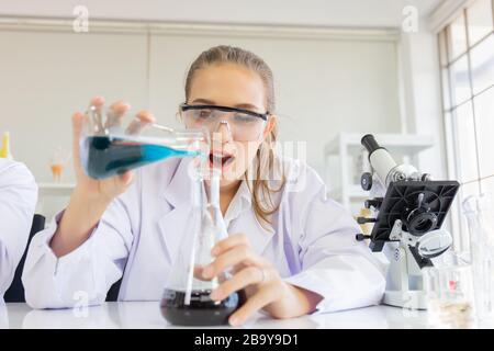 Une belle scientifique féminine travaille dans un laboratoire scientifique avec divers équipements dans le laboratoire. Banque D'Images