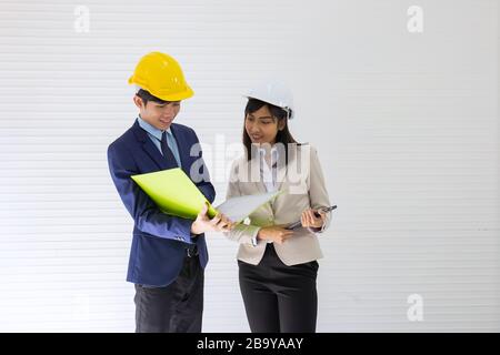 Deux contremaître asiatique, homme et femme, portant un casque, debout et parlant sur le site de l'événement Banque D'Images