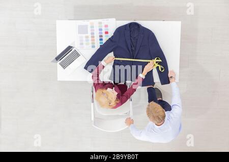 Topview les concepteurs professionnels de travail d'équipe, les jeunes hommes et les femmes âgées dans le bureau avec une variété de tons de tissu et d'équipement pour divers modèles.