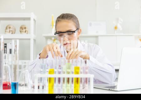 Une jeune scientifique féminine travaille dans un laboratoire scientifique doté de divers équipements dans le laboratoire. Banque D'Images