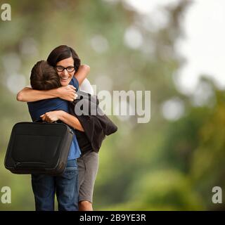 Femme d'affaires saluant son jeune fils. Banque D'Images