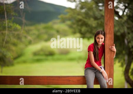 Portrait de la jeune fille assise sur la véranda dans un cadre rural. Banque D'Images