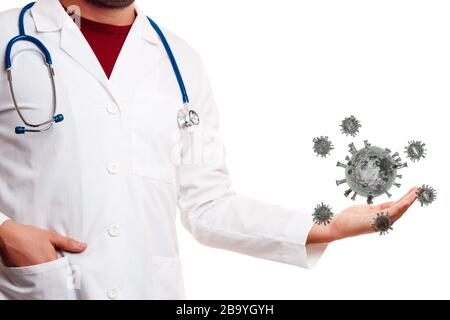 Le médecin inreconnaissable en manteau blanc tient le coronavirus dans la paume de sa main sur fond blanc en studio Banque D'Images