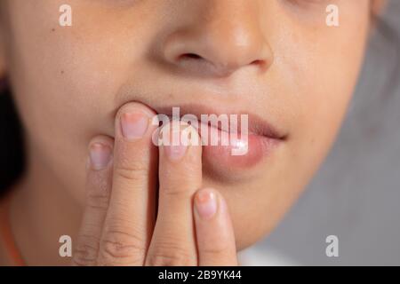 Très près de la bouche de l'enfant toucher - concept montrant pour empêcher et éviter de toucher votre bouche. Protéger contre la propagation du COVID-19 ou du coronavirus Banque D'Images