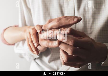 Un homme enlève un anneau de mariage de son doigt. Le mari trompe sa femme. Le concept de trahison. Banque D'Images