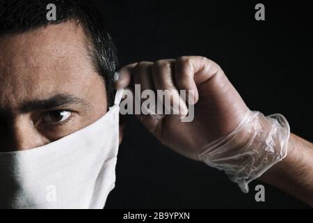 portrait sombre d'un homme portant un masque médical de protection sur fond noir, concept de coronavirus et protection contre les virus et les bactéries, se Banque D'Images