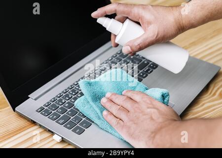 ordinateur désinfectant pour les mains avec spray antibactérien et un chiffon, concept d'hygiène et protection contre les virus et les bactéries, foyer sélectif Banque D'Images