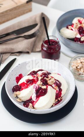Crêpes au fromage cottage avec sauce cerise, crème sure et noix caramélisées. Banque D'Images