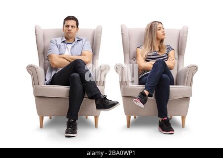 Jeune homme et femme en colère assis dans des fauteuils en regardant sur le côté isolé sur fond blanc Banque D'Images