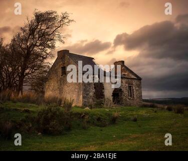 Maison traditionnelle en pierre de chaume dans la campagne irlandaise. Abandonné, il est délabrés dans le paysage d'hiver. Banque D'Images