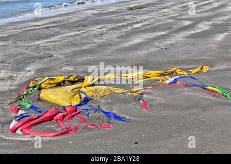 Tente en polyester colorée à la marée entrante le long de la plage côtière. Banque D'Images