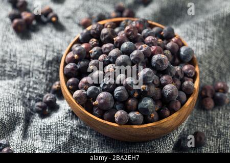 Berries organiques violettes brutes Juniper dans un bol Banque D'Images