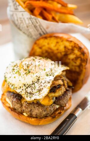 hamburger avec des œufs frits et des frites de pommes de terre douces Banque D'Images