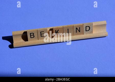 Soyez aimable, lettres en bois alphabet sur fond bleu avec espace de copie Banque D'Images