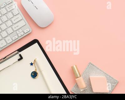 Souris de clavier, presse-papiers avec outils de maquillage de stylo, produits cosmétiques isolés sur un fond de couleur rose-pêche avec espace de copie. Couche plate, copie de la vue supérieure Banque D'Images