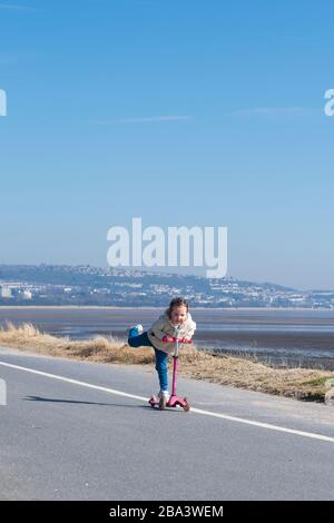 Une jeune fille qui fait de l'exercice quotidien sur la promenade en bord de mer habituellement animée de Mumbles. Un gouvernement est en place pour la pandémie de Covid-19 et les gens ne le sont pas Banque D'Images