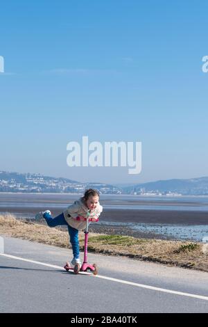 Une jeune fille qui fait de l'exercice quotidien sur la promenade en bord de mer habituellement animée de Mumbles. Un gouvernement est en place pour la pandémie de Covid-19 et les gens ne le sont pas Banque D'Images