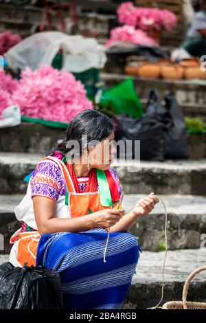 Un vendeur traditionnel travaille sur un métier dans le marché libre de Cuetzalan, Puebla, Mexique. Banque D'Images