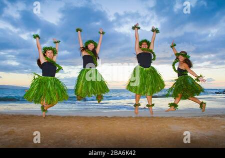 Quatre danseurs hula sautent pour la joie à Palauea, Maui. Hawaï. Banque D'Images
