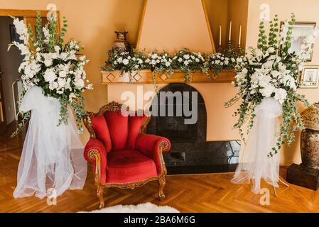 Salon spécialement décoré. Fauteuil, cheminée et fleurs Banque D'Images