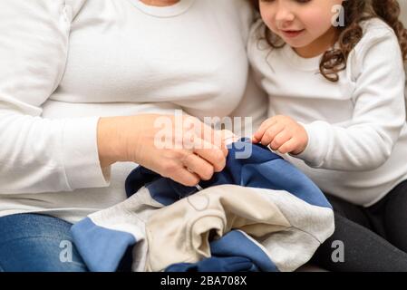 Grand-mère enseigne sa petite-fille aux vêtements MEND. Enfant ayant été homeschoolé en raison de l'arrêt de l'école pendant la pandémie de Covid-19. Banque D'Images