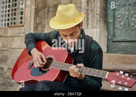 Charmant jeune musicien de rue avec guitare Banque D'Images