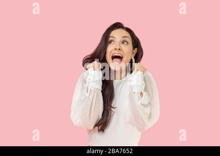 Jeune femme dans un chemisier blanc qui a l'air excitée Banque D'Images