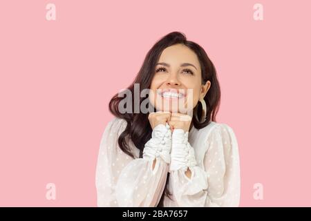 Jeune femme dans un chemisier blanc à l'air rêveuse Banque D'Images