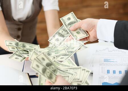 Homme d'affaires et femme d'affaires comptant de l'argent sur la table au bureau avec des mains très beaucoup de dollars de salaire pour le proche avenir Banque D'Images