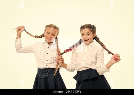 Aider les cheveux pousser plus vite. Adorables petits enfants prendre soin de cheveux longs. Petit mignon girl holding longs cheveux tresses, isolé sur blanc. Porter les cheveux longs en tresses pour l'école. Banque D'Images