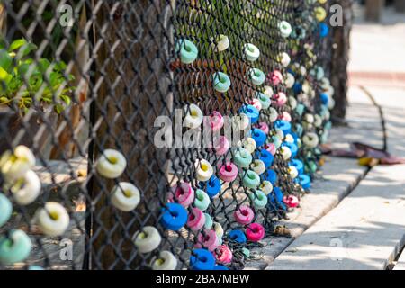 Décorations douces colorées et rondes accrochées sur la clôture en filet près du chemin en bois en Thaïlande. Le centre de la photo est mis au point par l'appareil photo Banque D'Images