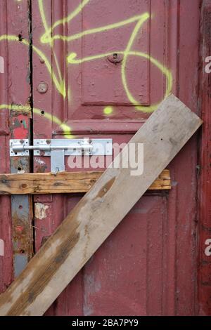 porte verrouillée et barrée vers un bâtiment redondant vide Banque D'Images